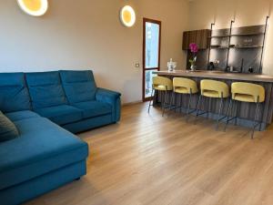 a living room with a blue couch and a kitchen at Luce di Mare in Quartu SantʼElena +12 photos