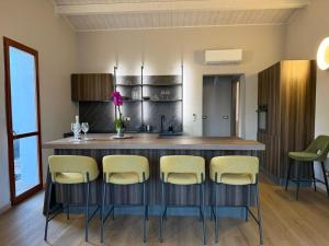 a kitchen with a bar with stools around it at Luce di Mare in Quartu SantʼElena