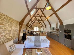 a living room with a white couch and a kitchen at La Source de Diège in Loupiac