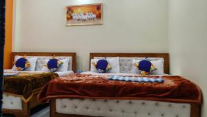 a bedroom with two beds with blue pillows at narayan home stay in Ayodhya