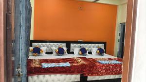 a bedroom with a bed with an orange wall at narayan home stay in Ayodhya