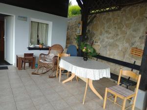 a table and chairs in a room with a stone wall at David Linea House in Volavlje