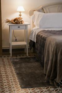 a bedroom with a bed and a table with a lamp at Alma de Barro in El Puente del Arzobispo