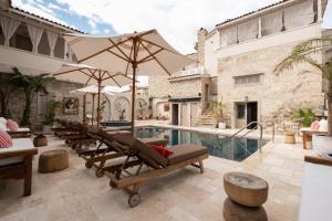 an outdoor patio with chairs and a swimming pool at Viento Alacati Hotel in Alaçatı