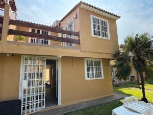 ein Haus mit offener Tür im Hof in der Unterkunft Casa Cayo in Ixtapa