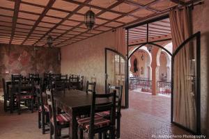 a dining room with a wooden table and chairs at Riad Belvedere in Ouzina
