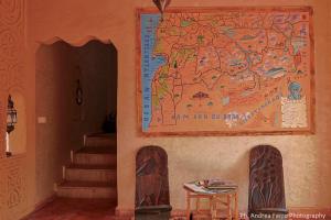 a map on the wall of a building with a table at Riad Belvedere in Ouzina
