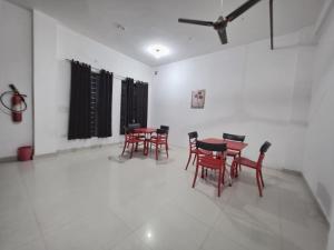 a dining room with red chairs and a table at Hotel Hilson in New Delhi