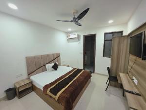 a bedroom with a bed and a ceiling fan at Hotel Hilson in New Delhi