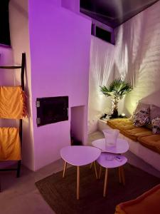 a room with a purple room with a couch and a table at Tu Casita Rural in Valdilecha