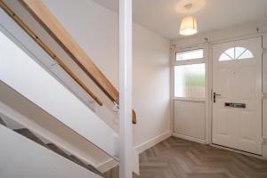 a hallway with a white door and a window at Willow retreat in Royal Tunbridge Wells