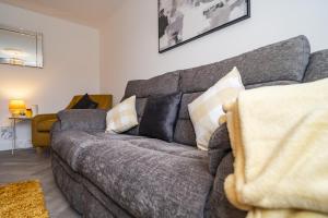 a living room with a gray couch with pillows at Willow retreat in Royal Tunbridge Wells