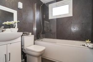 a bathroom with a toilet and a sink and a bath tub at Willow retreat in Royal Tunbridge Wells