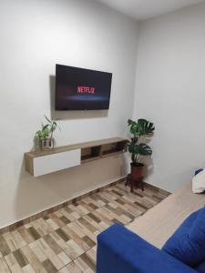 a living room with a tv on a wall at Haurea House in São Luís