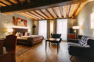 a bedroom with a bed and a couch and a table at Altstadt Hotel Stadtkrug in Salzburg +117 photos