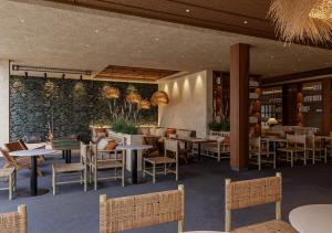 a restaurant with tables and chairs and a stone wall at HD Sensarena - Adults Only in Costa Teguise