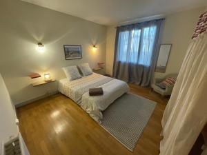 a bedroom with a bed and a window at Le Sam in Brive-la-Gaillarde