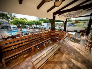 a large wooden bench in a patio with a pool at Punta Blanca Ocean Suites in Santa Elena