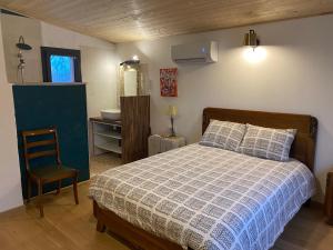 a bedroom with a bed and a chair in it at Chambre Lucioles in Orniac