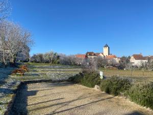 a field with benches and a building in the background at Chambre Lucioles in Orniac