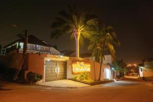 a building with a sign on the side of it at night at Chambre La Villa Kalanga in Abidjan