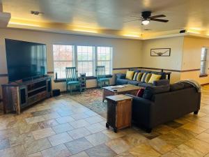 a living room with a couch and a flat screen tv at Hilltop Bastrop Retreat in Bastrop