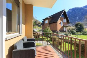 a balcony with two chairs and a house at La Casa Del Tasso in Feriolo