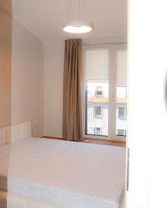 a bedroom with a bed and a large window at Prie jūros in Melnragė