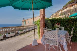 a table and chairs under an umbrella on a patio at Villa Flora - Goelba in Capoliveri