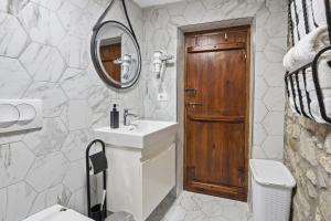 a bathroom with a sink and a wooden door at Villa Kokoshi, an extraordinary experience. in Berat +13 photos