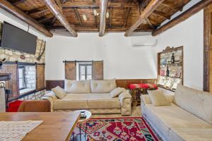 a living room with two couches and a table at Villa Kokoshi, an extraordinary experience. in Berat