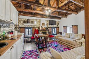 a kitchen and living room with a couch and a table at Villa Kokoshi, an extraordinary experience. in Berat