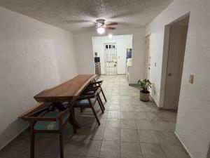 ein Esszimmer mit einem Holztisch und Stühlen in der Unterkunft Casa Cayo in Ixtapa