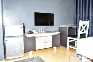 a room with a desk with a tv and a chair at Rymach homes in Eldoret