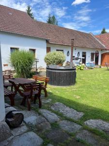 Ein Picknicktisch und Bänke vor einem Haus in der Unterkunft Apartmány Adéla in Český Rudolec