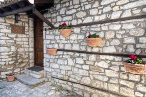 a stone wall with potted plants on it at Villa Kokoshi, an extraordinary experience. in Berat