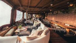 a room with a bunch of couches and tables at Zman Midbar Eco Spirit Lodge for Peace in Arad