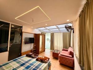 a bedroom with a bed and a couch and a tv at Kp's Riverland Resorts in Madwa