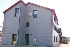 a large gray building with a door on the side of it at Prie jūros in Melnragė