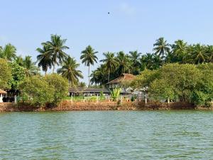 a house on the shore of a body of water at Kp's Riverland Resorts in Madwa +5 photos