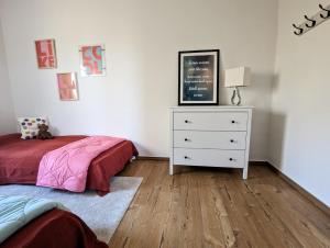 a bedroom with a bed and a dresser with a lamp at Ferienhaus Swanen Hus in Nordstrand