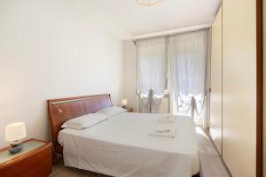 a bedroom with a white bed and a window at La Casa Del Tasso in Feriolo
