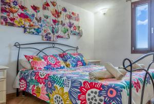 a bedroom with a bed with a colorful bedspread at Bed & Bike Casa dei Papi in Portoferraio