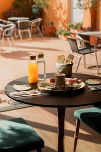 a table with a plate of food and orange juice at L'Agora Hotel in Bocairent