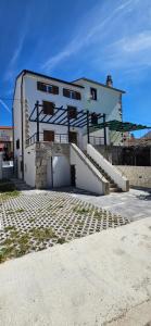 a white building with a staircase in front of it at LUXURY Rooms Punat in Punat