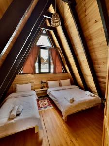 two beds in the attic of a log cabin at Chill inn kazbegi in Kazbegi