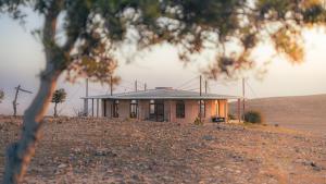 a house on a hill in the middle of a field at Zman Midbar Eco Spirit Lodge for Peace in Arad