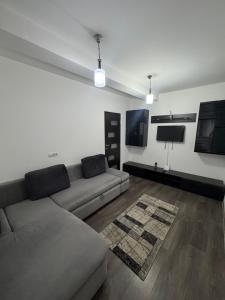 a living room with a couch and a tv at Apartament Yuk in Bragadiru