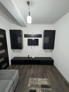 a living room with a couch and a tv at Apartament Yuk in Bragadiru