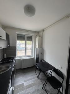 a small kitchen with a table and a refrigerator at Apartament Yuk in Bragadiru